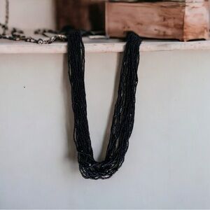 Very long multi multi strand black seed bead necklace.